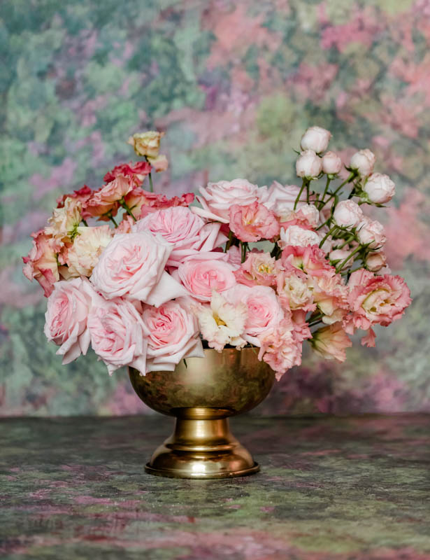 mix of pink roses in gold vase