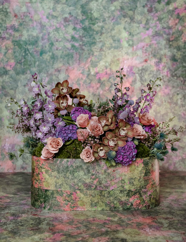 mix of purple and brown blooms in oval box