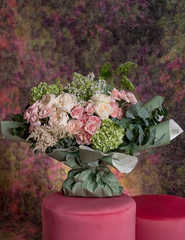 Mix of green hydrangea and pink blooms in a vase